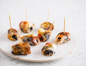 Prunes and gorgonzola wrapped in maple-glazed pancetta