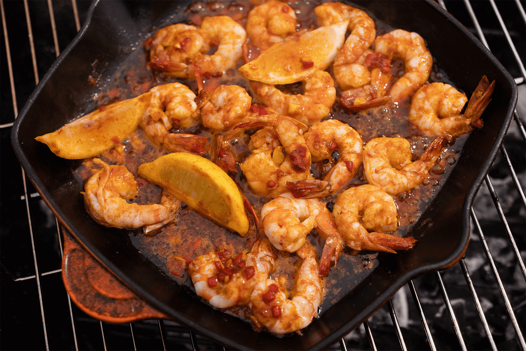 Sizzling maple king prawn in a skillet on a grill